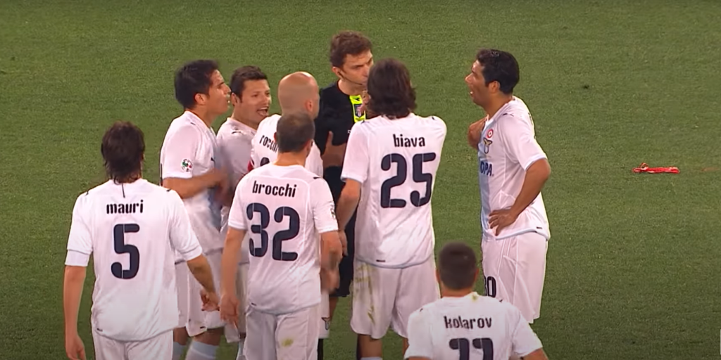 Lazio players surround referee